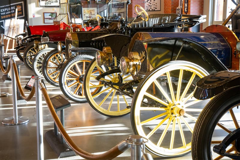 A collection of early 20th century vehicles, many from the beloved brass era in the main lobby of Gasoline Alley